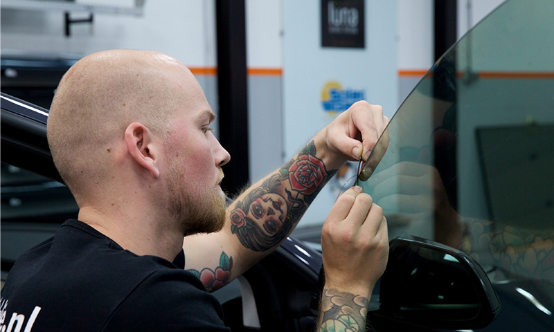 Medewerker autoraamfolie monteren